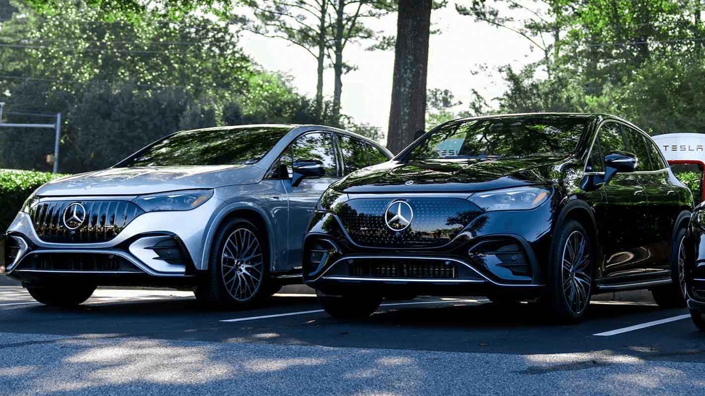 Two Mercedes-Benz EVs parked at a Tesla Supercharger station