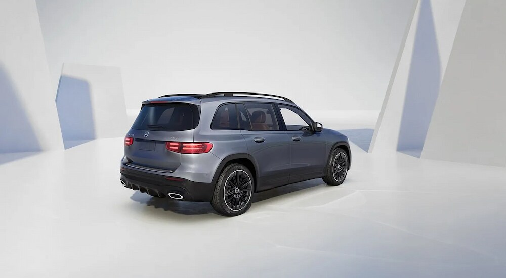 Rear view of a grey 2025 Mercedes-Benz GLB250 4MATIC parked in a modern showroom.