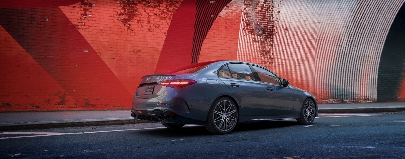A grey 2025 Mercedes-Benz AMG C 43 is shown near a brick wall.