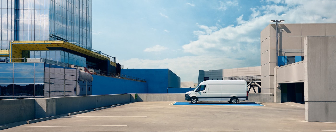 A white 2024 Mecedes-Benz eSprinter Cargo Van parked on a rooftop parking garage.