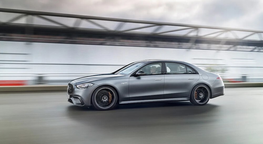 A silver 2024 Mercedes-Benz AMG E63 S is shown driving on bridge.