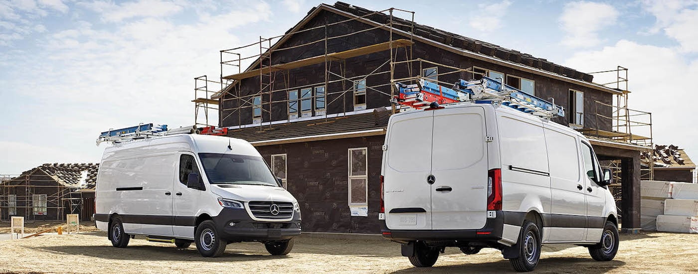 A pair of white 2024 Mercedes-Benz Sprinter Vans are shown parked on a jobsite.