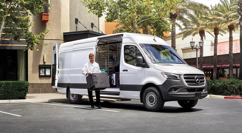 A white 2025 Mercedes Sprinter 4500 is parked outside of a store.