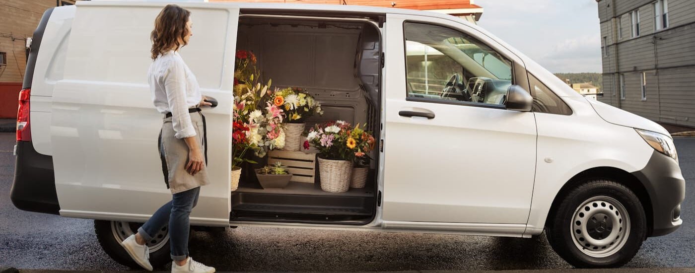 A white 2024 Mercedes-Benz Metris is shown parked near a flower shop.