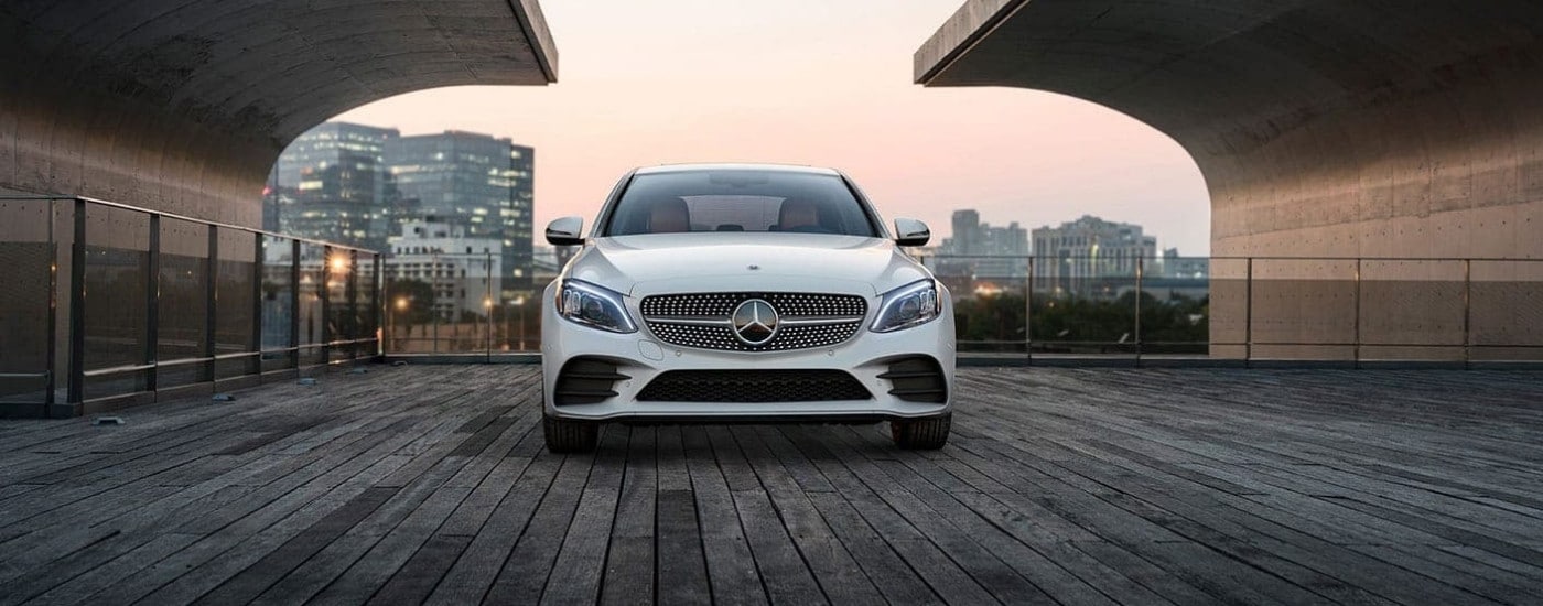 A white 2020 Mercedes-Benz C-Class is shown overlooking a a city.