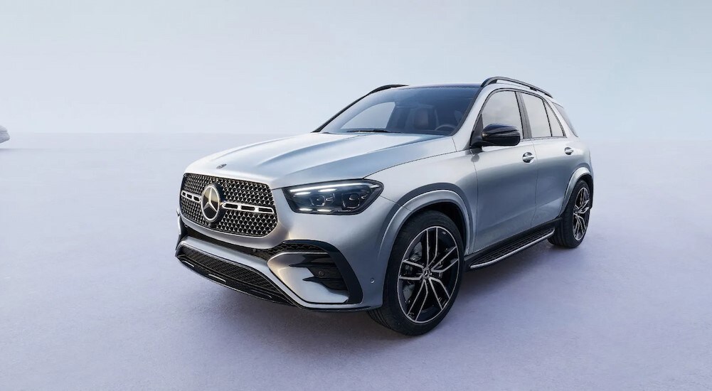 A silver 2024 Mercedes-Benz GLE SUV is shown parked on a beach.