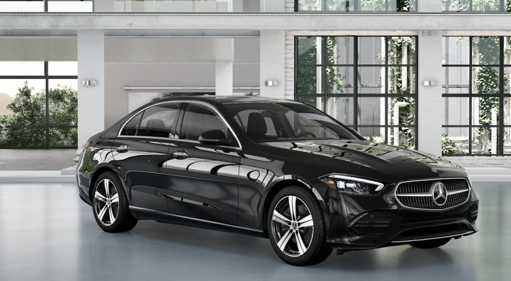 A black 2024 Mercedes-Benz C 300 parked in the showroom of a Mercedes-Benz dealer.