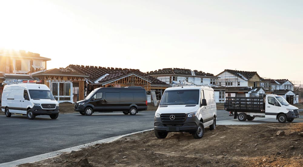 A group of 2024 Mercedes-Benz Sprinter Vans are parked at a construction site.