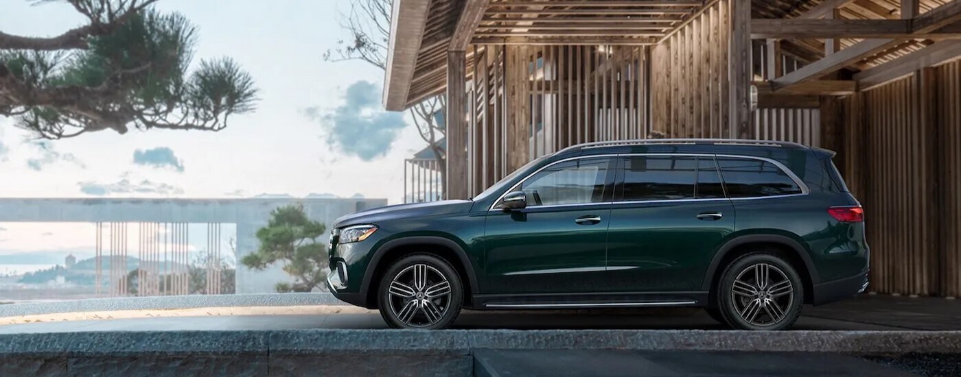 Side view of a green 2023 Mercedes-Benz GLS 450 parked at a construction site.