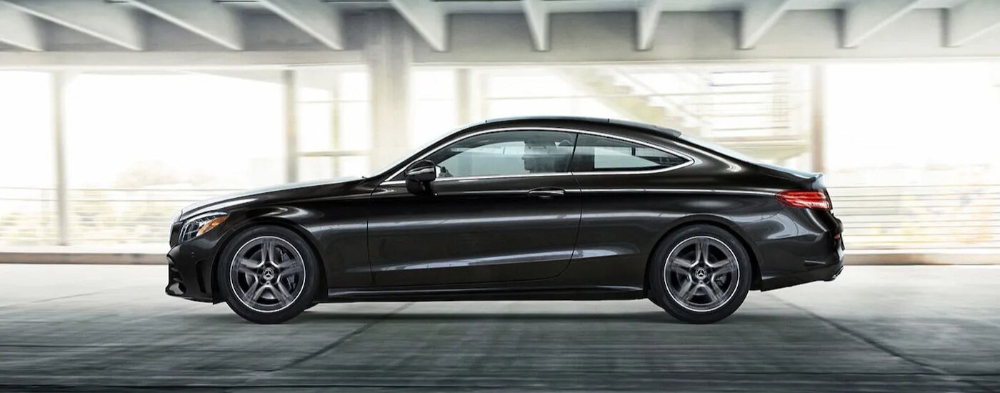 A popular used Mercedes-Benz for sale, a black 2023 Mercedes-Benz C300, is shown from side driving in a tunnel.