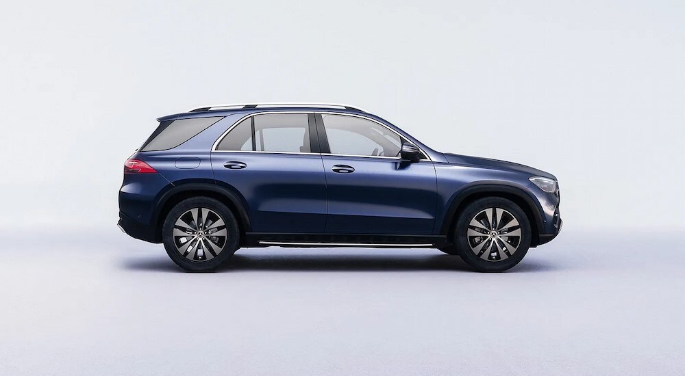 A blue 2024 Mercedes-Benz GLE SUV is shown parked in a light blue room.