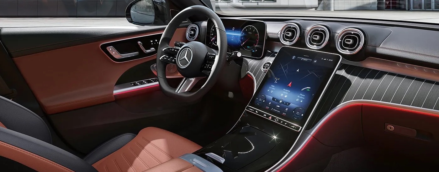 The large infotainment screen and brown leather upholstery in a 2023 Mercedes-Benz C 300 Pinnacle at a Mercedes-Benz dealer.
