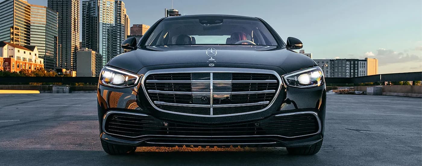 A black 2024 Mercedes-Benz S-Class is parked on an empty parking lot after viewing a used Mercedes-Benz for sale.