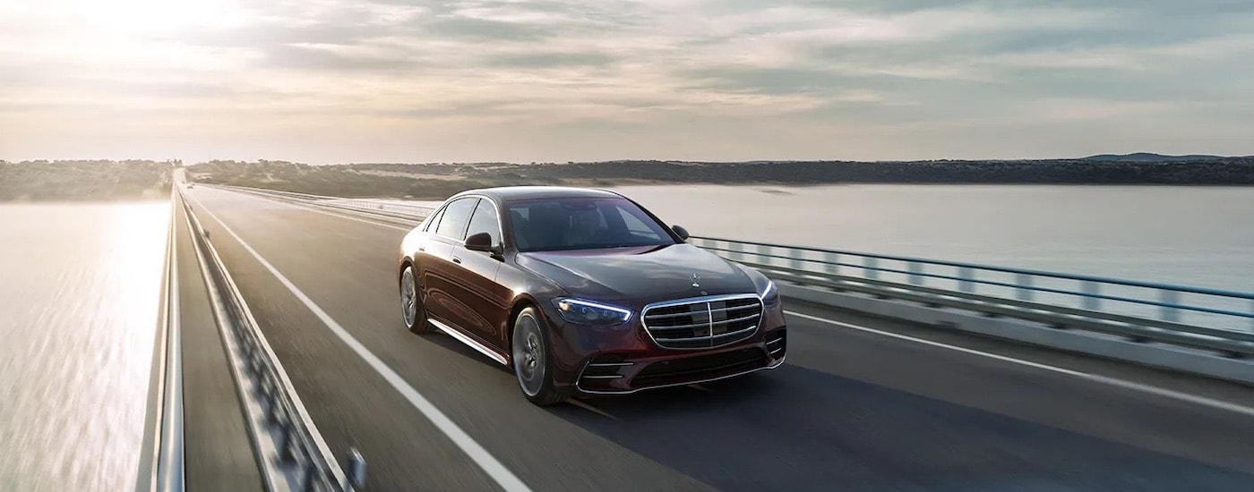 A maroon 2024 Mercedes-Benz S-Class Sedan is shown from the front at an angle.