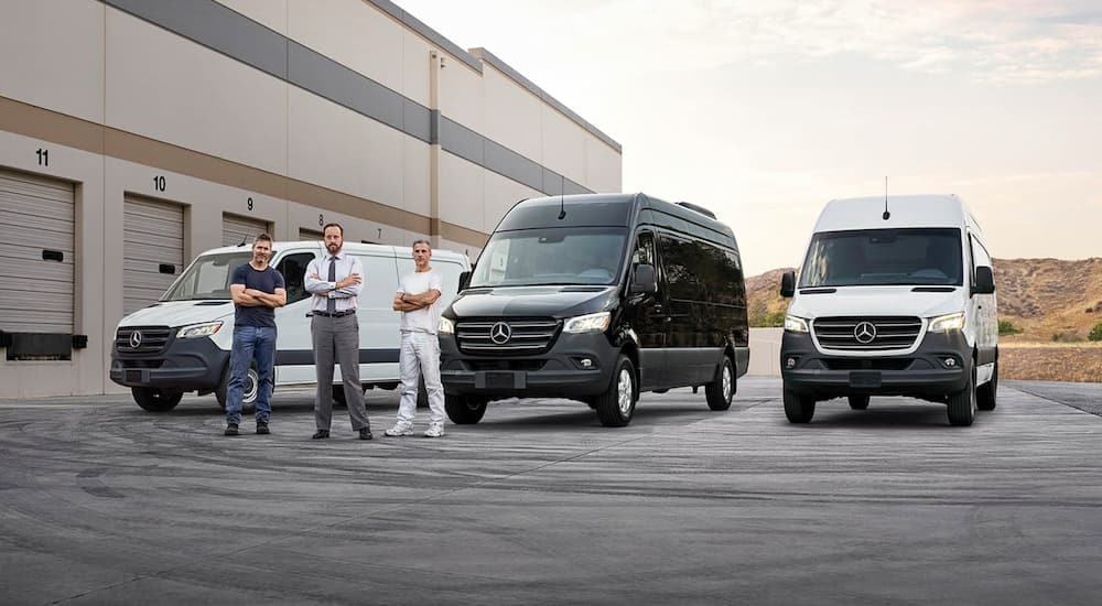 Three 2024 Mercedes-Benz Sprinter vans are parked outside of a warehouse.