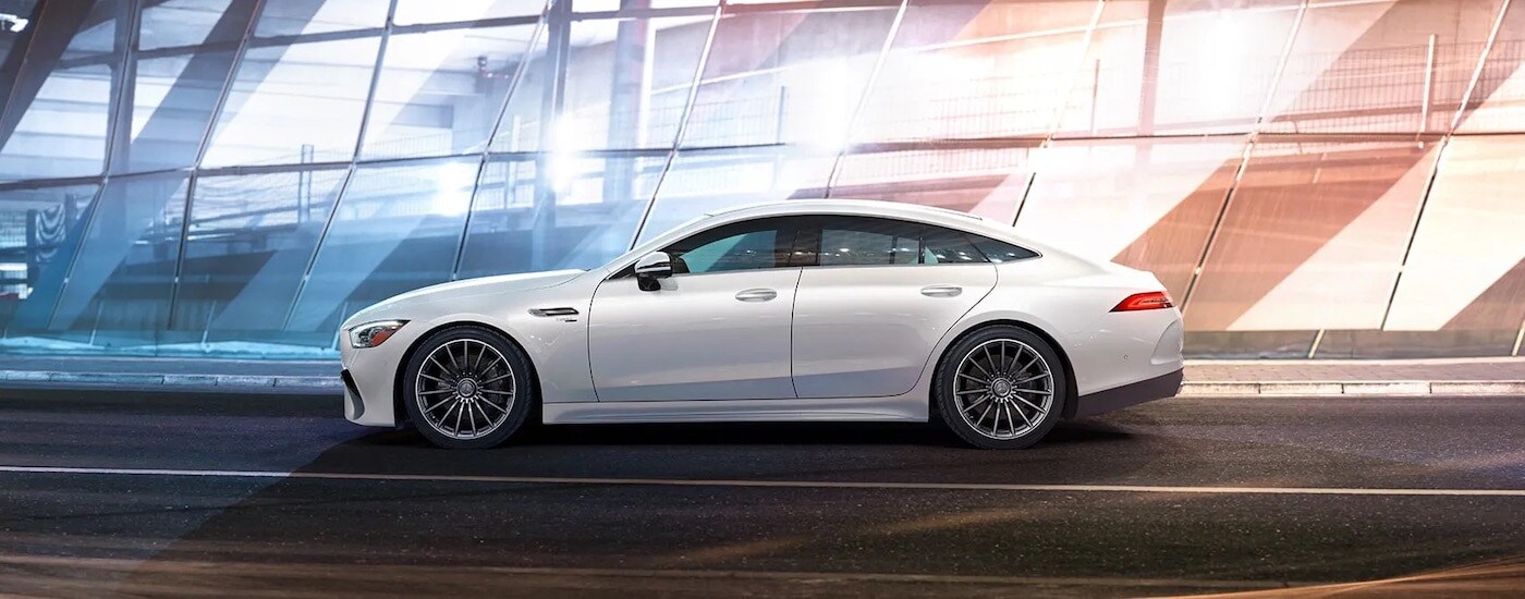 A white 2024 Mercedes-Benz AMG GT 4 Door Coupe is shown from the side after leaving a Mercedes-Benz dealer.