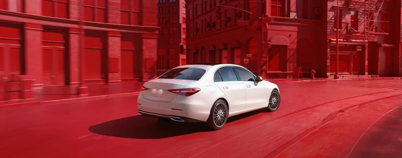 A white 2024 Mercedes-Benz C-Class is shown from the side after leaving a Mercedes-Benz dealer near Cottage Grove.
