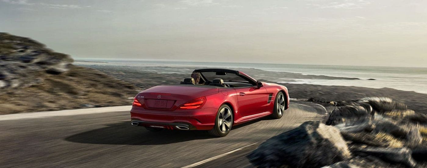 A red 2020 Mercedes-Benz SL Roadster is shown driving on a coastal road.