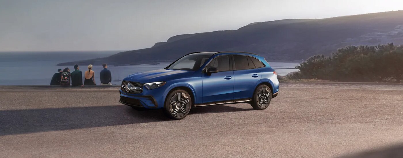Side view of a blue 2025 Mercedes-Benz GLC Pinnacle parked at the beach.