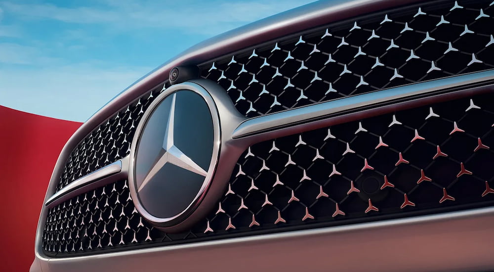 A close-up on the grille of a black 2024 Mercedes-Benz C 300 Exclusive