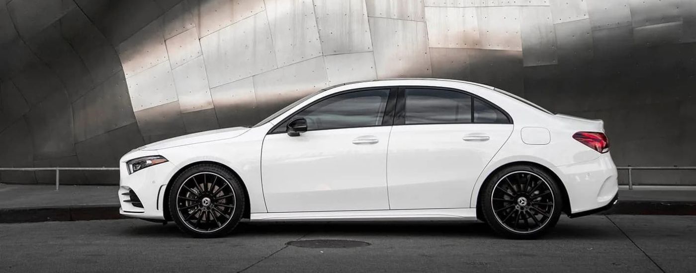 A white 2022 Mercedes-Benz A-Class is shown from the side in front of a metal wall.