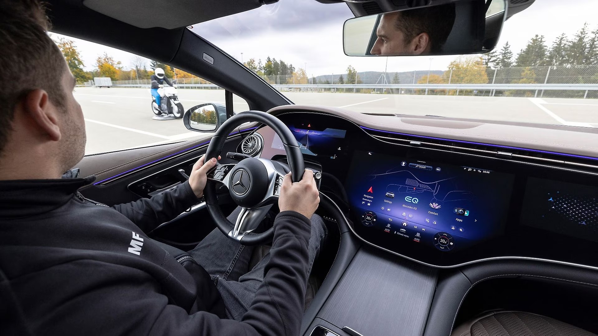 Man driving a Mercedes-Benz watching a motorcycle