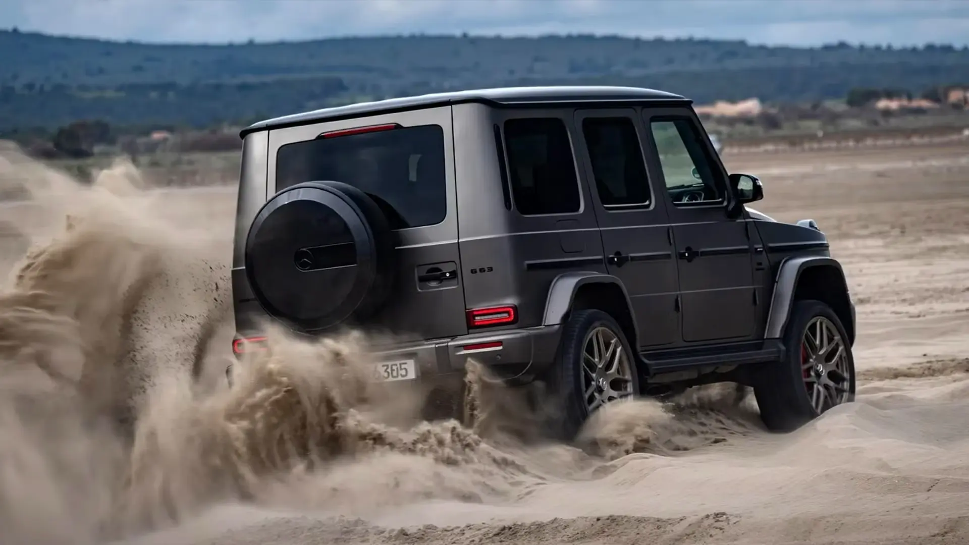 2025-mercedes-amg-g63-passenger-3.4-sand-driving-offroad.webp