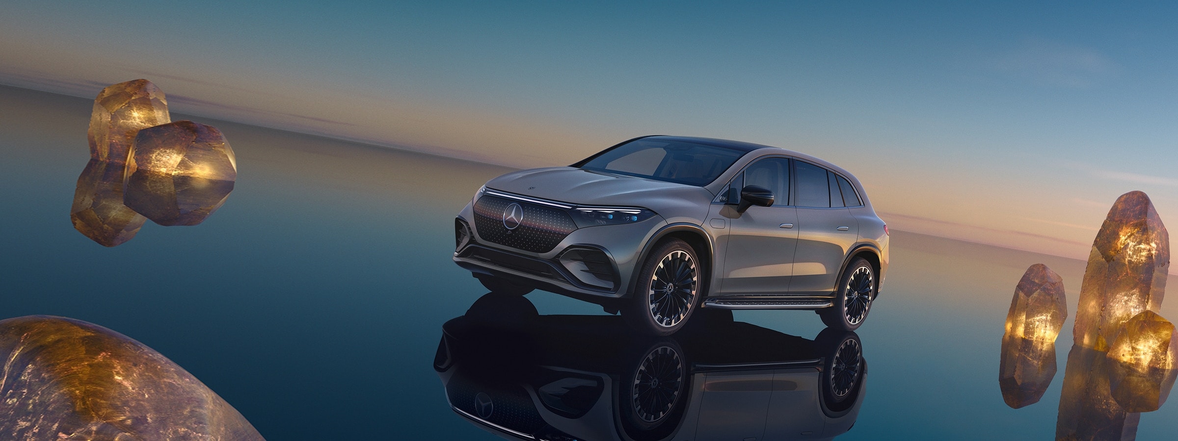 2023 EQS SUV on the beach in the evening with illuminated rocks