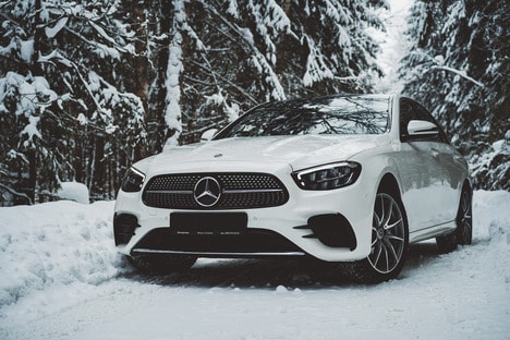 a white car parked on a snowy road