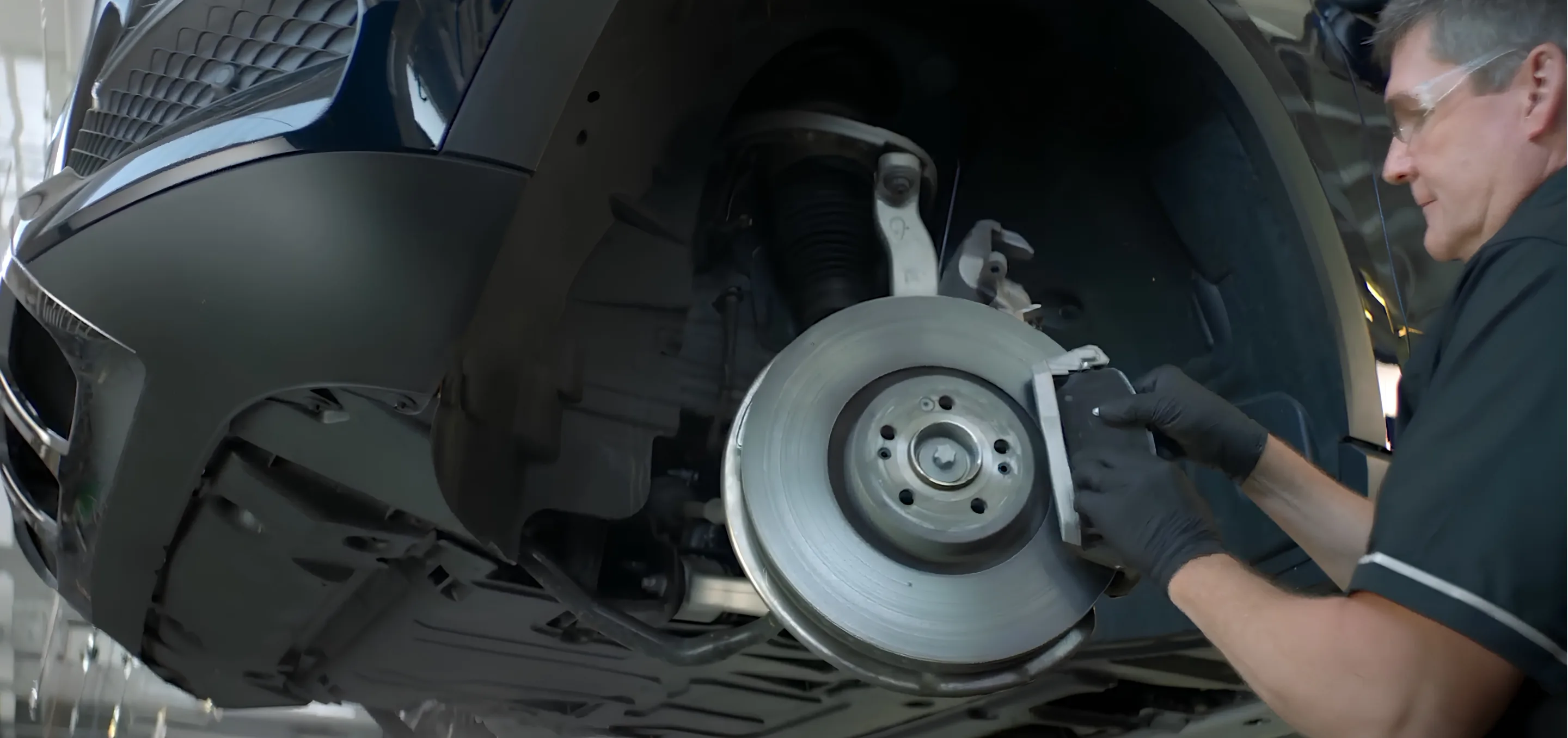 Mercedes-Benz Technician Installing New Brake Pads on a Front Rotor During Brake Service
