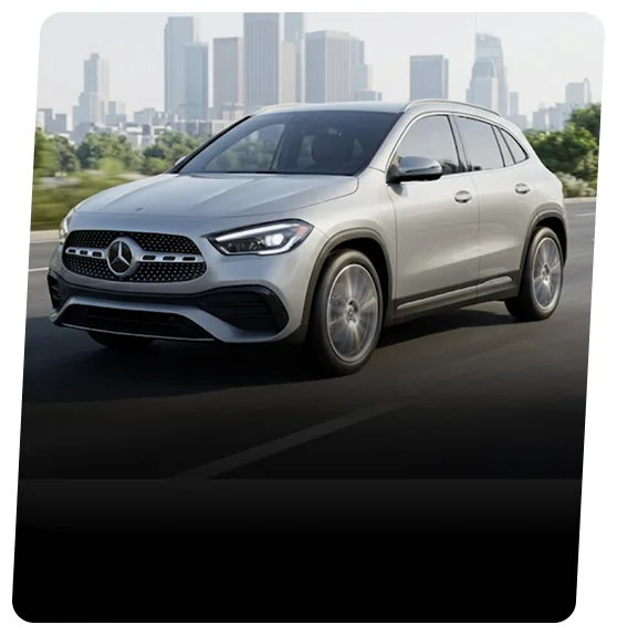 Silver Mercedes-Benz GLA SUV on a highway with a city skyline behind