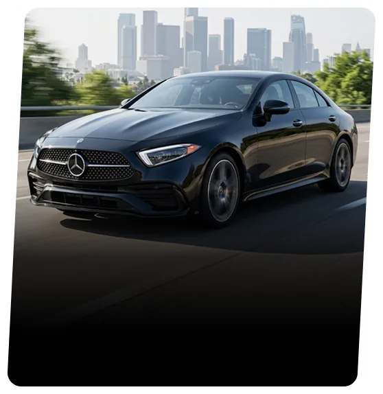 Mercedes-Benz coupe on a highway with a city skyline behind