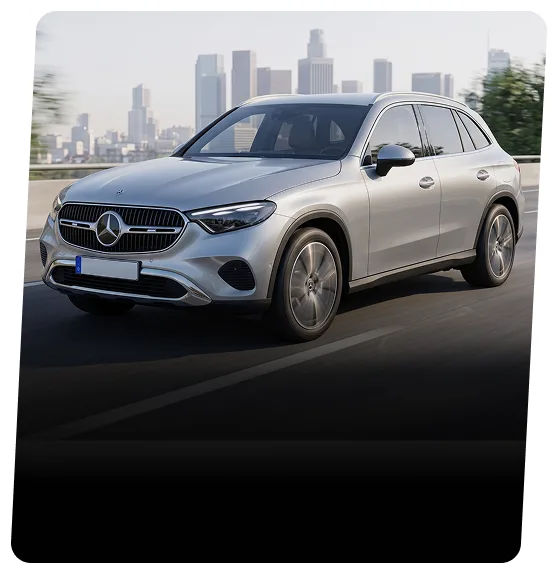 Silver Mercedes-Benz GLC on a highway with a city skyline behind
