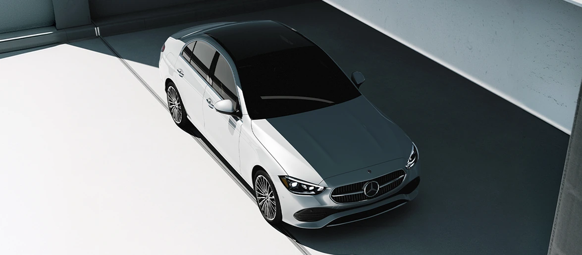 Overhead view of a white C-Class Sedan parked in angled light and shadow