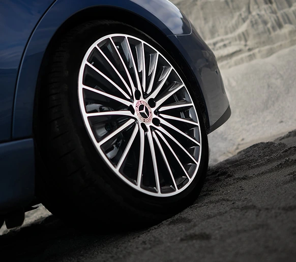 Close-up of a multi-spoke alloy wheel on a blue C-Class Sedan