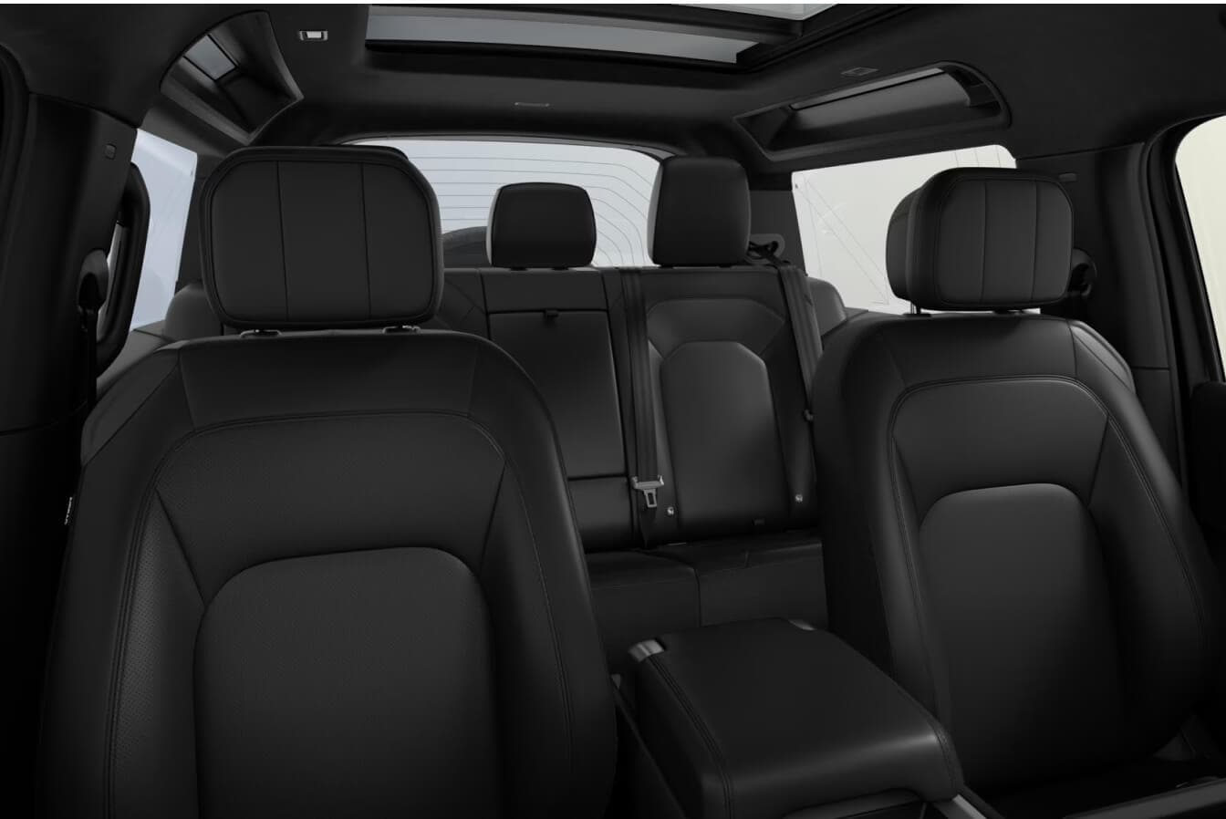 Interior view looking toward the rear seats of a 2026 Land Rover Defender 90 cabin upholstered in Ebony Windsor Leather.