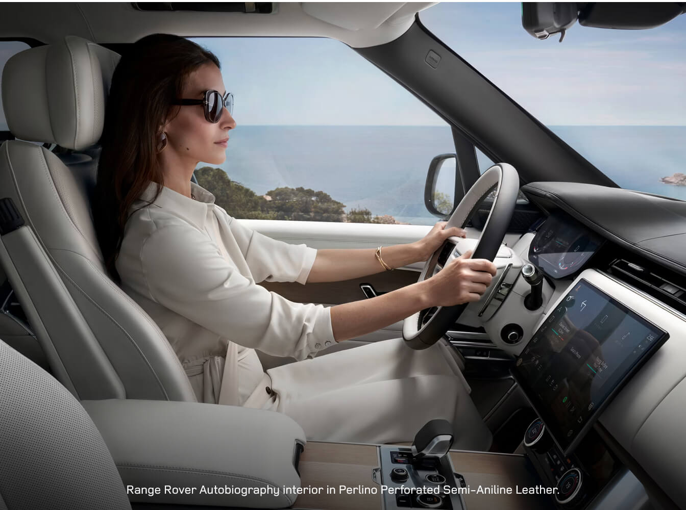 Interior view of a woman driving a Land Rover Range Rover Autobiography with a luxury Perlino leather cabin.