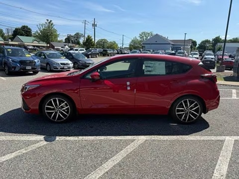 red 2027 Subaru Impreza sedan parked at the MetroWest Subaru dealership in Natick, MA