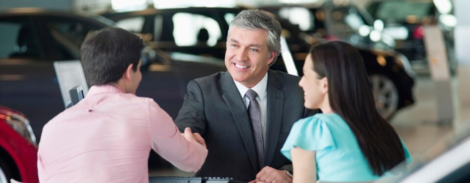 Car Dealership finance manager talking to a man and woman