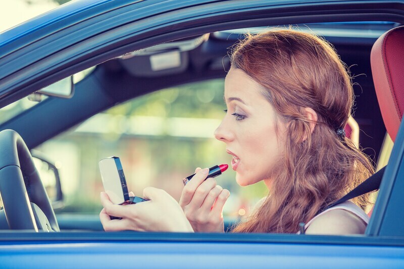 Driver applying lipstick
