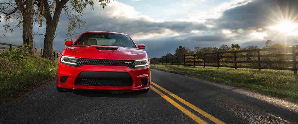 A red 2019 Dodge Charger driving on a country road