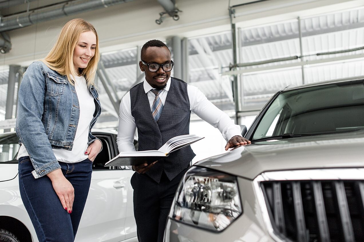 Salesman shows a woman a car.png