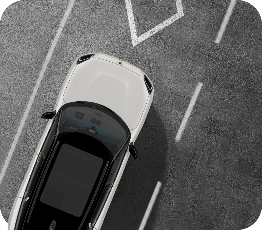 Overhead view of a green MINI vehicle with white roof parked on a pavement surface with white lane lines on each side of the vehicle.