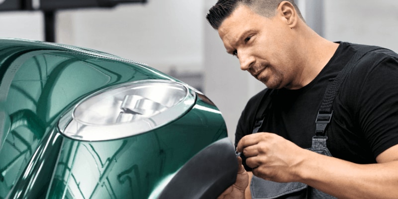 A man servicing a green MINI car
