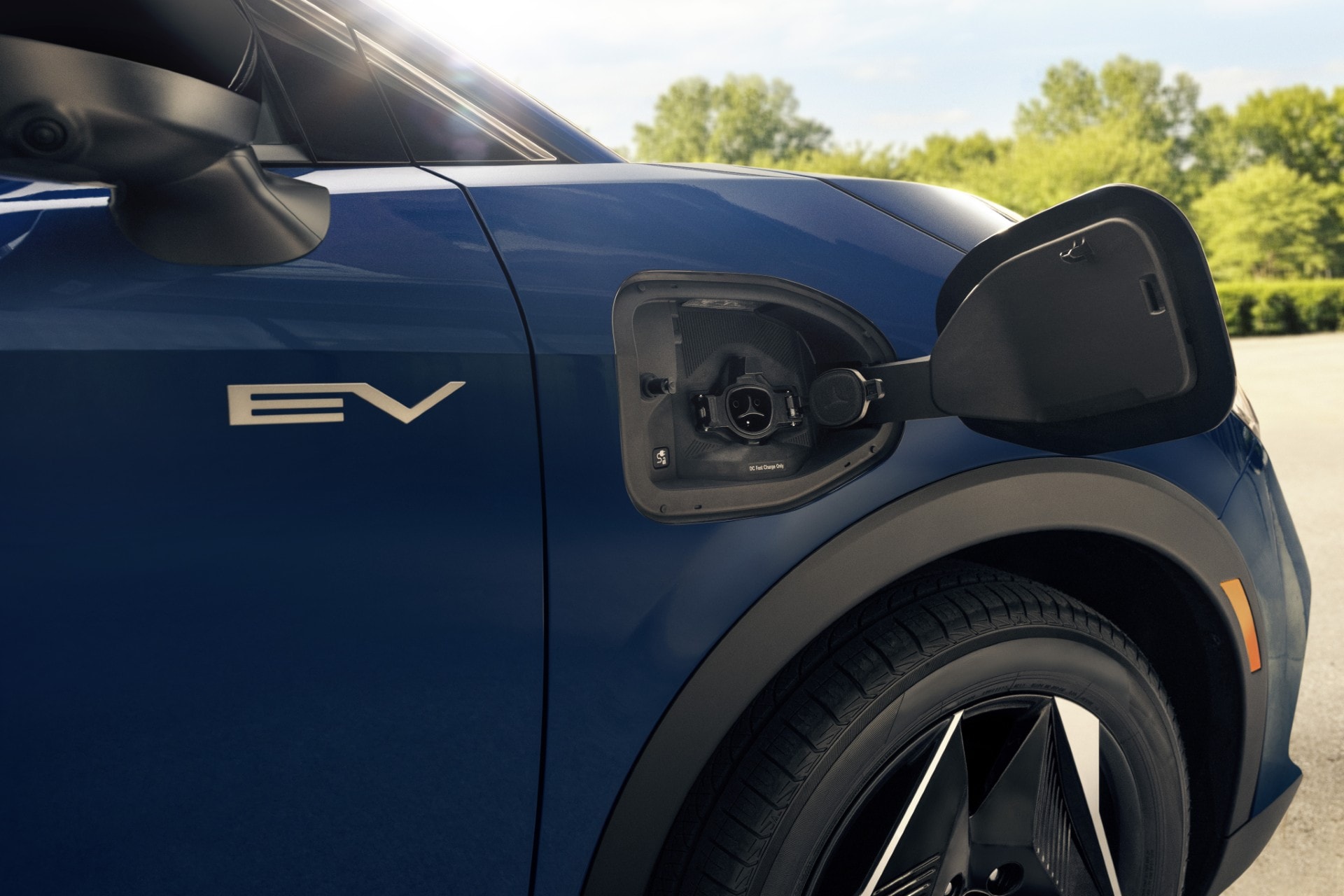 Man's hand plugging in the 2027 Eclipse Sportback EV on the drive side