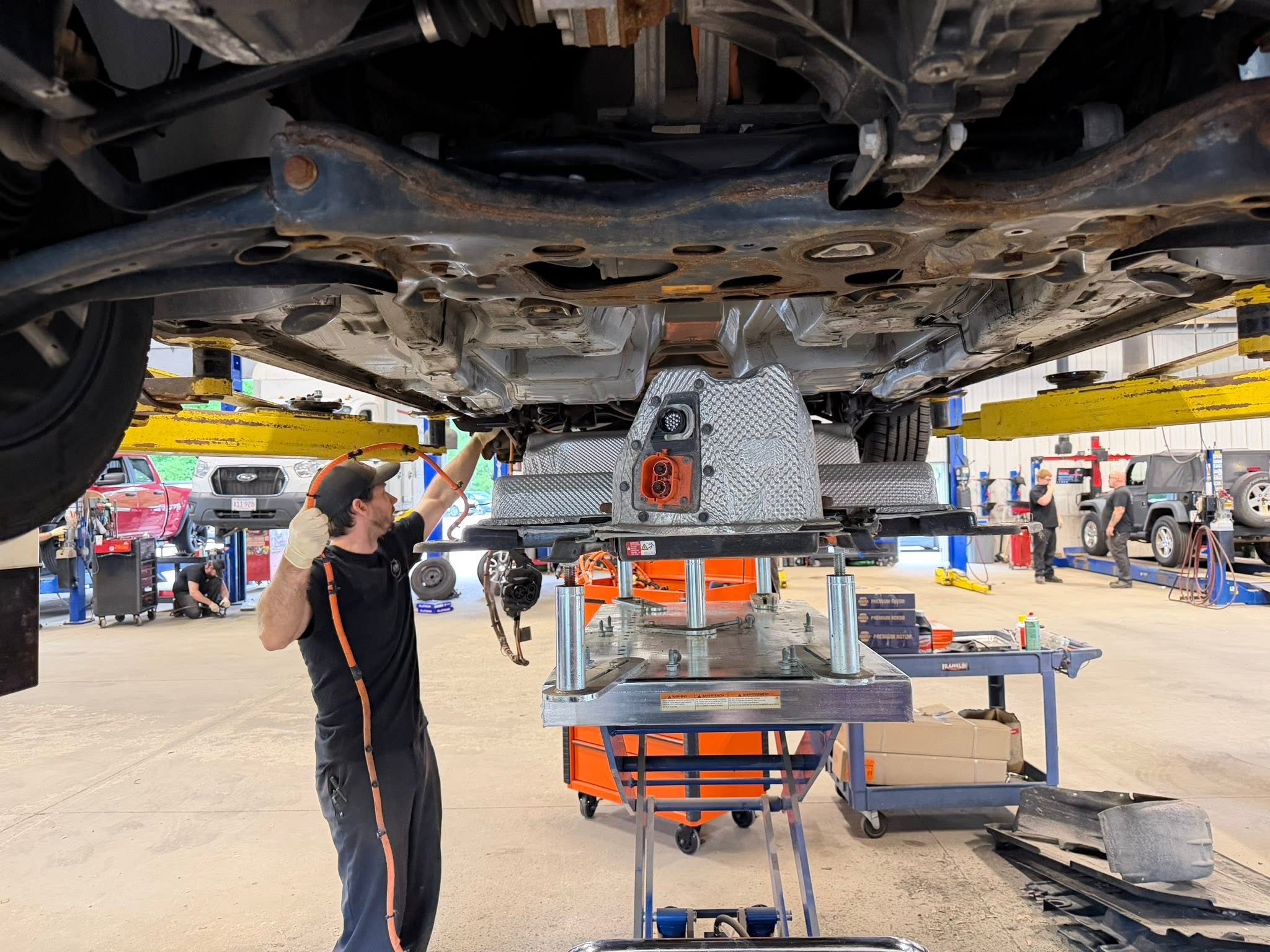 Certified technician servicing an electric vehicle at Modern Auto Sales in Tyngsboro, MA