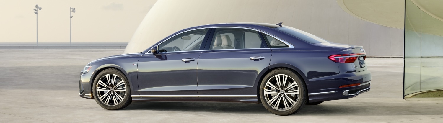 Audi A8 parked in front of an modern building