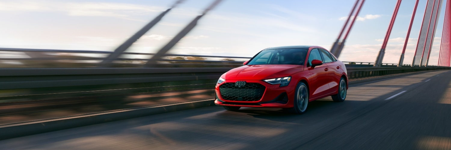 Red A3 driving across a suspension bridge