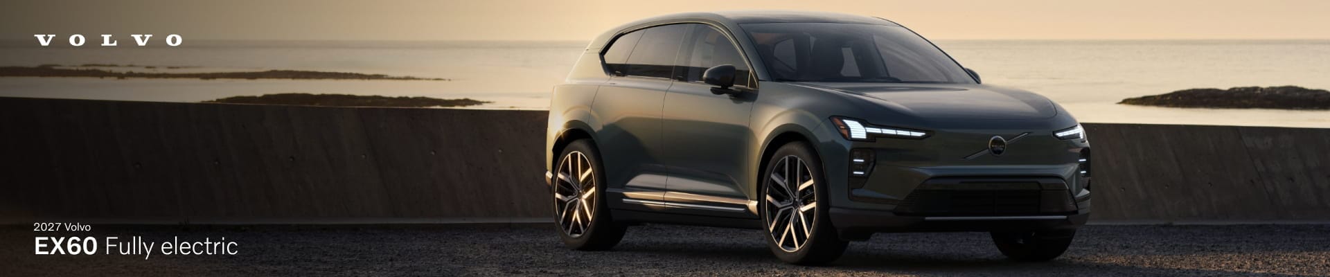 2027 Volvo EX60 fully electric SUV parked near a coastal road at sunset.