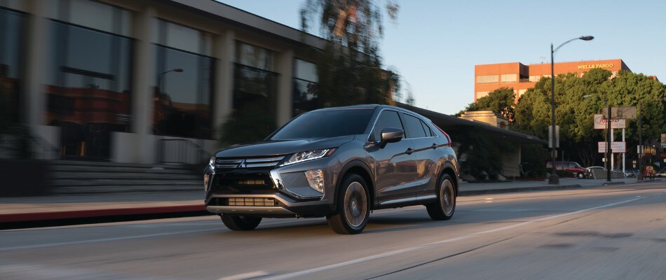 ES vs. LE A silver 2018 Mitsubishi Eclipse Cross driving through a city